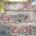 Placas conmemorativas en un muro rústico de ladrillo en Hernando, Argentina, en honor a Difunta Correa.