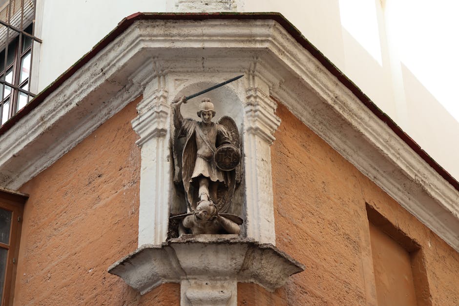 Vista detallada de la estatua de San Miguel Arcángel en una calle histórica de Cádiz, España.