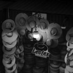 Fotografía artística en blanco y negro de un puesto de sombreros en el mercado local de Arequipa, Perú.