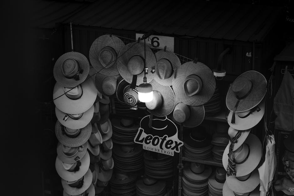 Fotografía artística en blanco y negro de un puesto de sombreros en el mercado local de Arequipa, Perú.