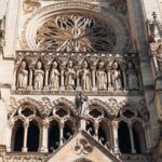 Primer plano detallado de la arquitectura gótica de la Catedral de Amiens, que muestra esculturas ornamentadas y un rosetón.