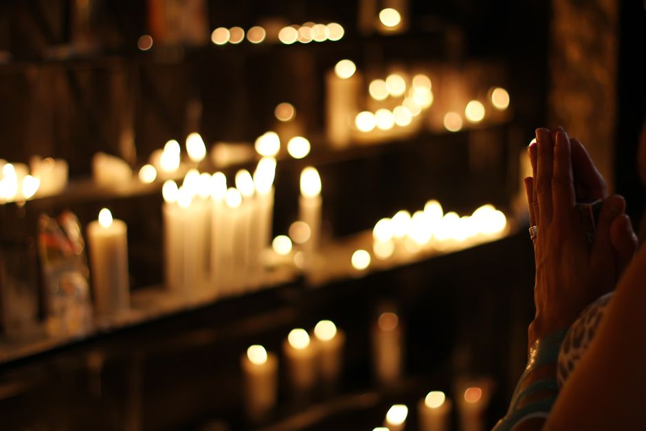Cerrar Fotografía De Persona Rezando Delante De Velas Forradas